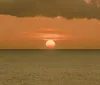 Four smiling individuals are enjoying a boat ride at sunset