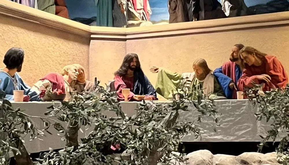The image depicts a life-sized diorama or tableau representing the biblical scene of The Last Supper featuring figures resembling Jesus and his disciples gathered around a table