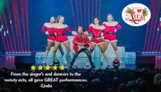 A young boy in a red jacket plays an electric guitar on stage, surrounded by four dancers in festive red and white outfits.
