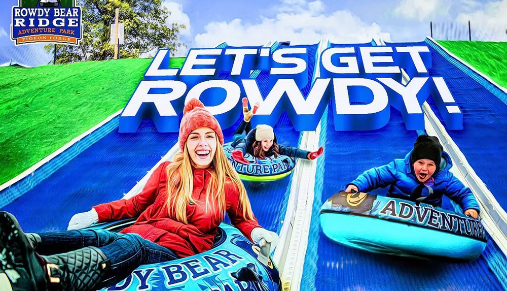 Three people are visibly enjoying a ride down a blue outdoor slide at Rowdy Bear Ridge Adventure Park as indicated by the bold text LETS GET ROWDY overhead