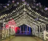 A joyful couple is enjoying a festive night out surrounded by sparkly lights while the woman points at something interesting outside the frame