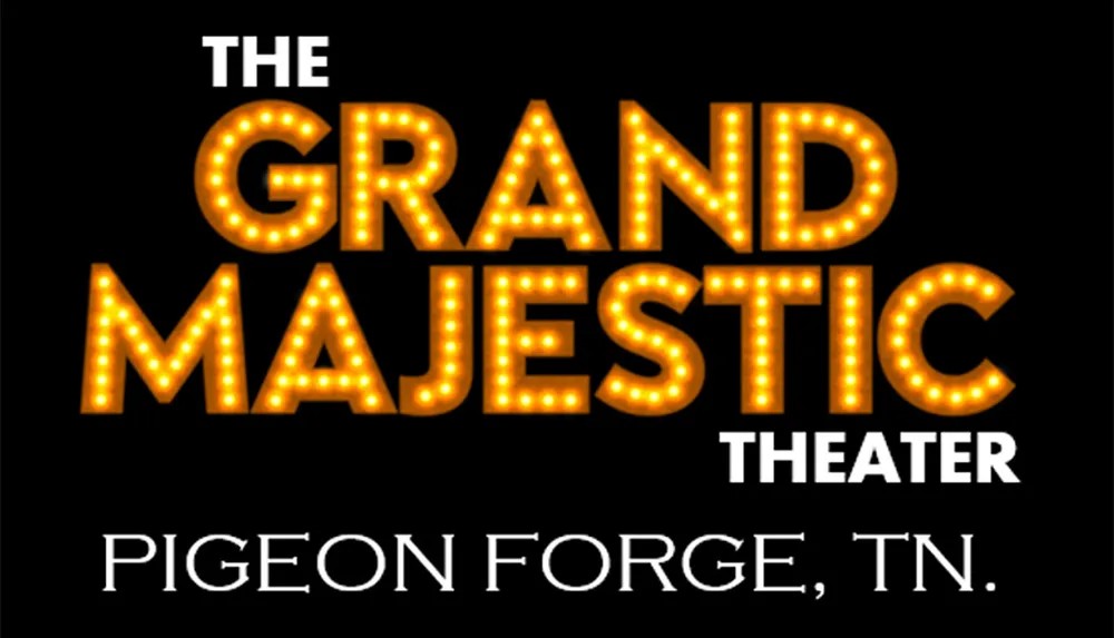 The image shows a lit-up sign with the text The Grand Majestic Theater Pigeon Forge TN with the letters styled to resemble a marquee with bright lights