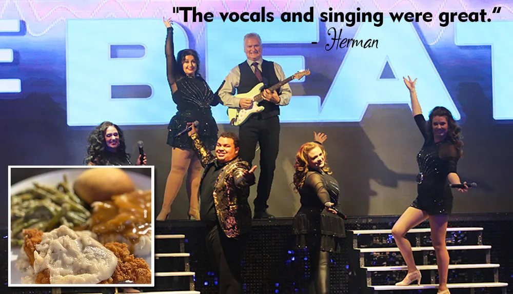 A group of performers is posing energetically on stage in front of a large sign with a positive quote about their singing and an inset image of a meal featuring chicken mashed potatoes and green beans