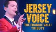A person in a red jacket is singing into a microphone next to text that says 