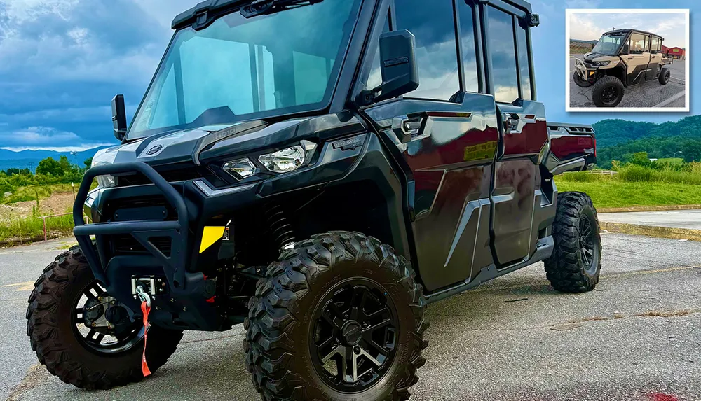 The image shows a rugged black all-terrain vehicle with large tires parked outdoors with a small inset showing an alternate view