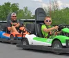 Two children are enjoying themselves while driving go-karts on a track lined with tires