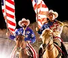 The image features three people in cowboy attire riding horses and holding American flags with an inset of a hearty meal and the text Great show Great food with a Yelp logo