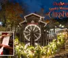 The image shows a festive Christmas scene at Dollywoods Smoky Mountain Christmas featuring a decorated watermill and an inset of Santa holding a Nice List