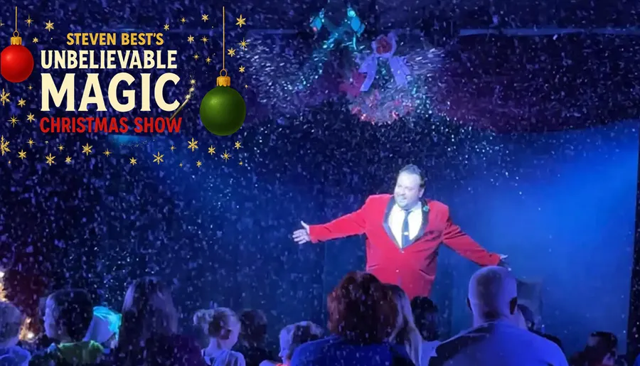 A performer in a red suit entertains a crowd during a festive Christmas magic show, with snow-like effects and decorations enhancing the holiday atmosphere.
