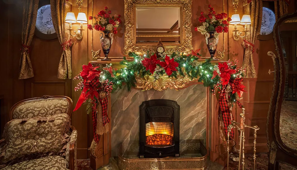 A lavishly decorated fireplace adorned with garlands poinsettias and warm lighting set in an elegantly furnished room