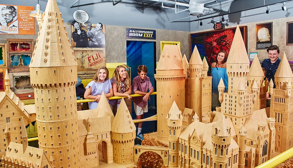 Visitors are enjoying an elaborate wooden castle display at an exhibition or museum