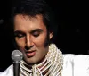 A person wearing an Elvis Presley-style costume is holding a microphone presumably performing or about to perform