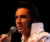 A person wearing an Elvis Presley-style costume is holding a microphone presumably performing or about to perform