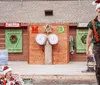 The image depicts a lively and colorful promotional scene for Paula Deens Lumberjack Feud Christmas Supper Show featuring a playful group of people dressed as lumberjacks along with a child in the foreground and a character dressed as Santa Claus holding a chainsaw