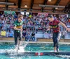 The image shows a collage with one photo depicting a man splashed with water in a celebratory moment at a sports game and an inset photo showcasing a selection of hearty meals accompanied by the quote Great time for the WHOLE FAMILY by Paula