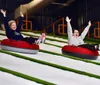 A young girl is joyfully sliding down in an orange Tube Pro water slide tube