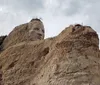 The image shows the iconic Mount Rushmore National Memorial with the carved faces of four American presidents set against a clear blue sky