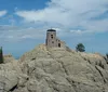 Tourists are gathered at an observation area to view the Mount Rushmore National Memorial which features the carved faces of four US presidents