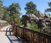 Tourists are gathered at an observation area to view the Mount Rushmore National Memorial which features the carved faces of four US presidents