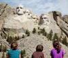 Three children are gazing at the monumental sculpture of four US presidents carved into Mount Rushmore
