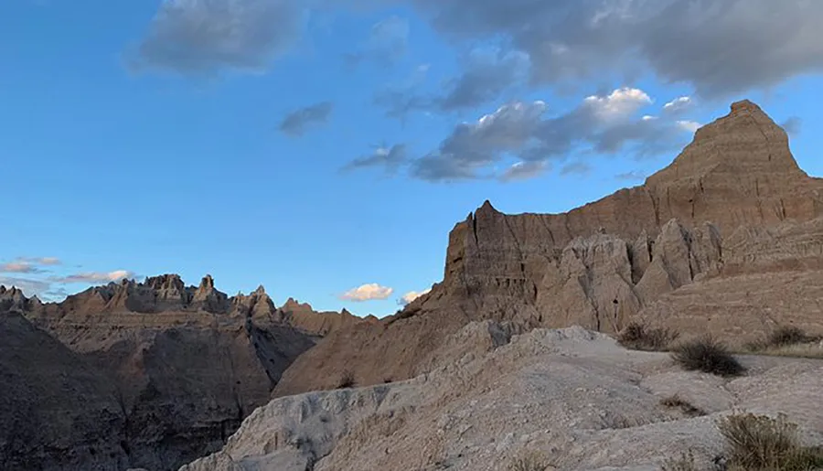 The image showcases a rugged, eroded landscape with distinctive rock formations under a cloudy sky.