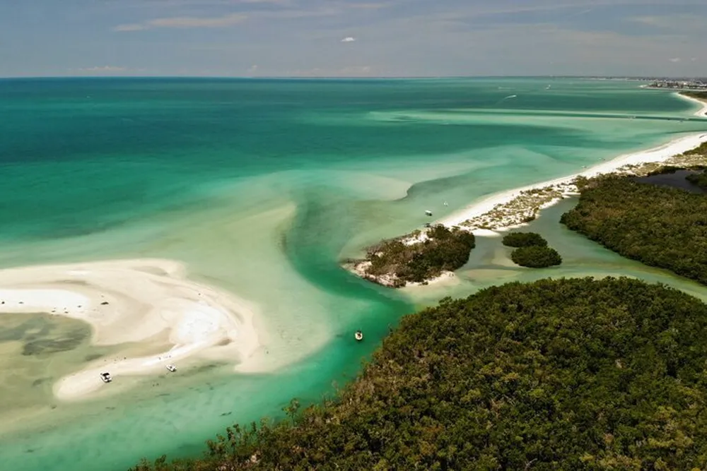 The image shows a serene aerial view of a tropical coastline with crystal-clear turquoise waters white sandy shores and lush greenery