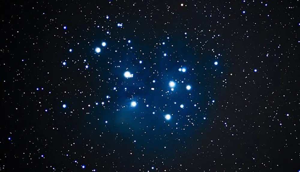 The image depicts the Pleiades star cluster also known as the Seven Sisters against the backdrop of space