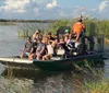 A group of people is enjoying an airboat tour through a marshy waterway