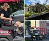 Three people are smiling and seated in a red golf cart parked on a city street on a sunny day