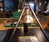 Visitors are engaged in examining a ship model and reading information on display at a maritime museum exhibit