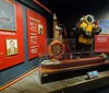 Visitors are engaged in examining a ship model and reading information on display at a maritime museum exhibit