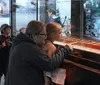 Visitors are engaged in examining a ship model and reading information on display at a maritime museum exhibit