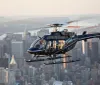 A helicopter is flying over a densely built urban area showcasing a citys skyline in the background