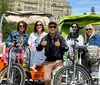 A group of happy tourists is enjoying a ride on pedicabs through a park on a sunny day