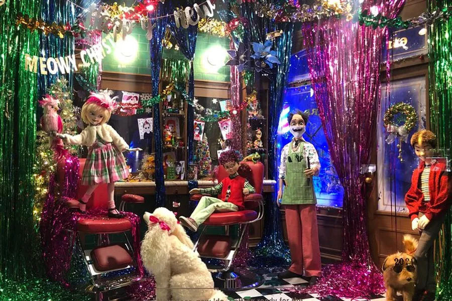 The image features a vibrant and colorful holiday-themed display with mannequins and animals in a festive and somewhat whimsical setting that includes a Meowy Christmas sign.
