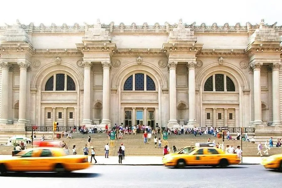 This is a bustling scene in front of a grand, neoclassical building with people ascending its steps and yellow taxicabs passing by in the foreground.