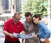 Three people are attentively examining a map or brochure on a city street