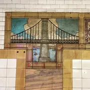 The image displays a mural of a bridge depicted in a stained glass art style on a tiled wall.