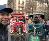 A group of cheerful people is enjoying a festive decorated pedicab ride on a city street