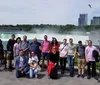 A group of people is posing for a photo in front of the misty backdrop of Niagara Falls with buildings visible in the background