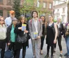 A group of people pose for a photo on a city street two of whom are holding books with visible covers