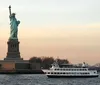 A ferry sails past the Statue of Liberty during what appears to be dusk or dawn