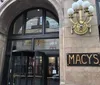 The image shows the exterior of a Macys department store with a distinctive arch and gold-colored signage