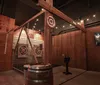 A person is seen throwing an axe towards a target in an indoor axe-throwing venue