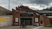 The image shows the facade of the Fort Pitt Museum with overcast skies above it.