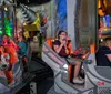 Thrilled riders express joy and excitement on a roller coaster as they descend a steep track under a sunny sky