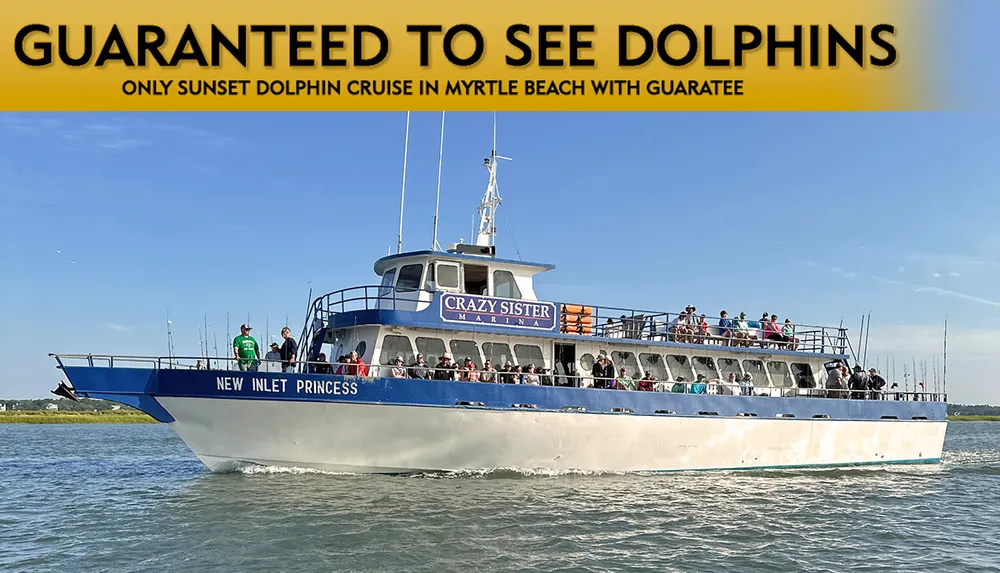 The image shows a large boat named New Inlet Princess from the Crazy Sister Marina filled with passengers cruising on the water with a promise of guaranteed dolphin sightings advertised in bold lettering above
