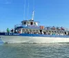 The image shows a large boat named New Inlet Princess from the Crazy Sister Marina filled with passengers cruising on the water with a promise of guaranteed dolphin sightings advertised in bold lettering above
