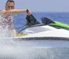 A person is riding a jet ski on choppy water with a stylized skull and crossbones graphic superimposed on the image