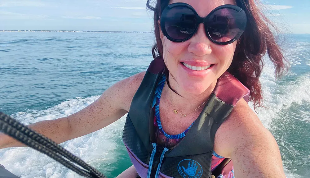 A person is taking a selfie while enjoying a jet ski ride on a sunny day at the sea